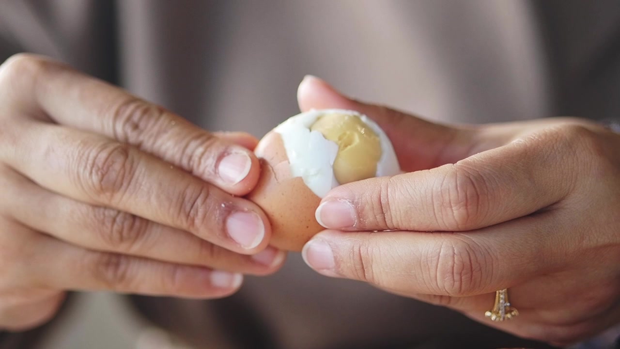 Person Peeling a Soft Boiled Egg