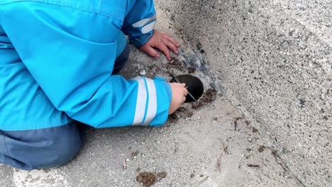 autistic boyin blue coverall is playing with sand