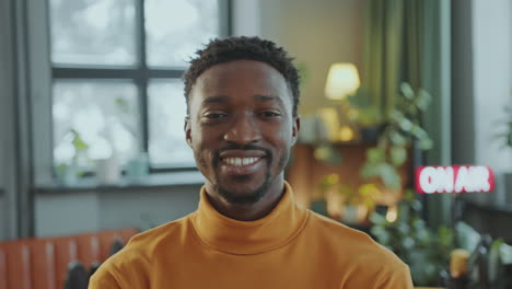 retrato de un hombre afroamericano con una sonrisa radiante en un estudio de grabación de podcast