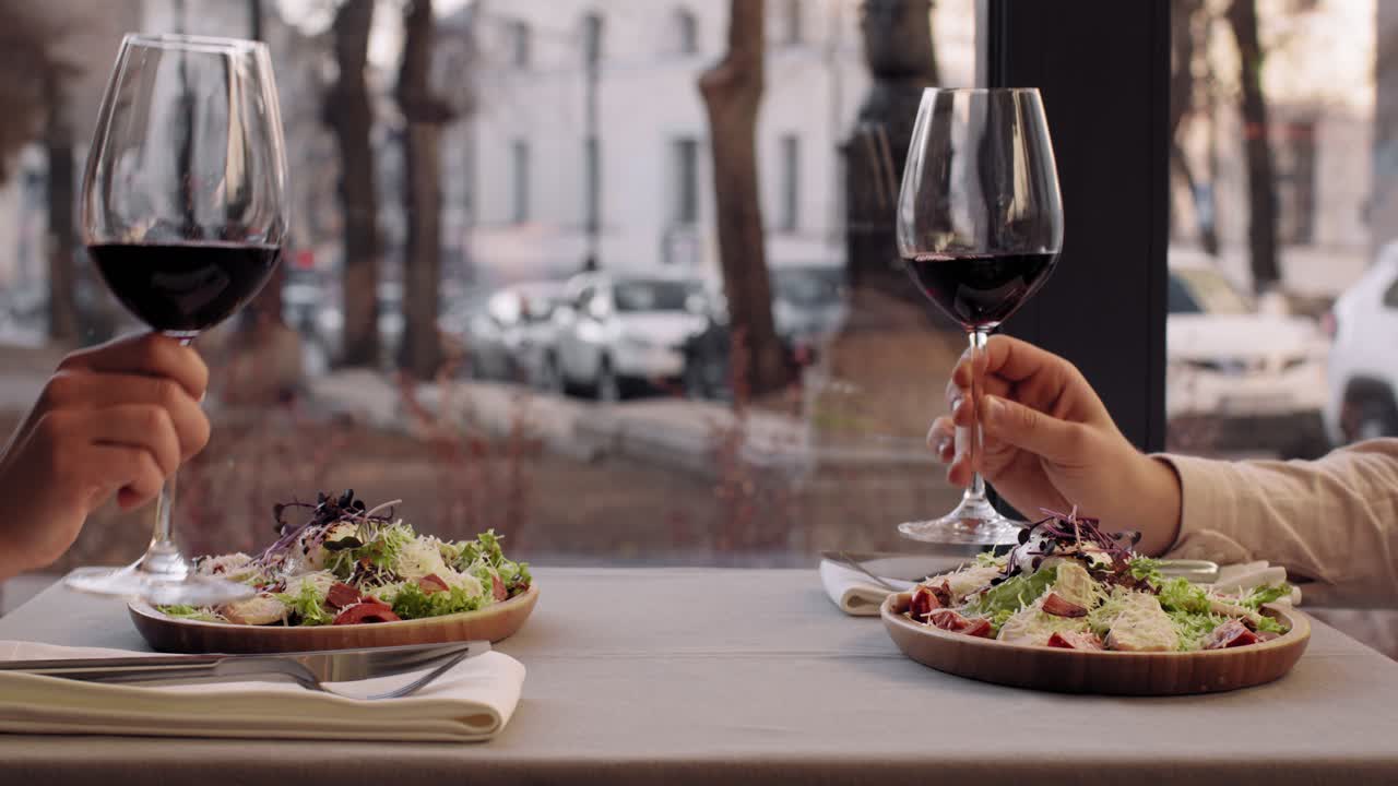 Coppia che festeggia la cena con vino rosso e Caesar Salad