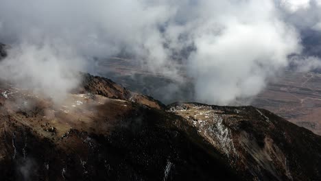 aerial shot of volcanic rocky mountainside and sulphuric clouds