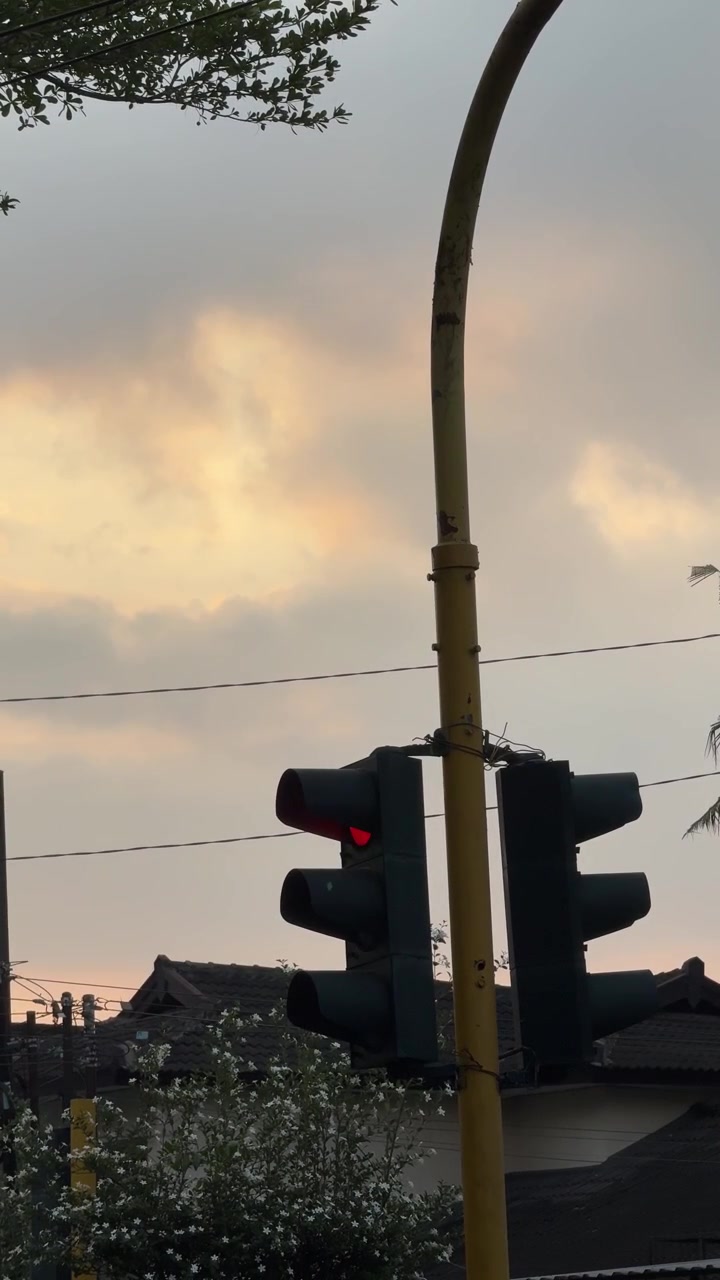 Lampu Lalu Lintas Merah dengan Latar Langit Senja Berawan