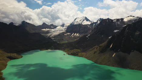 Panning-aerial-drone-shot-of-the-Ala-kol-lake-and-the-mountain-range-that-surrounds-it-in-Kyrgyzstan