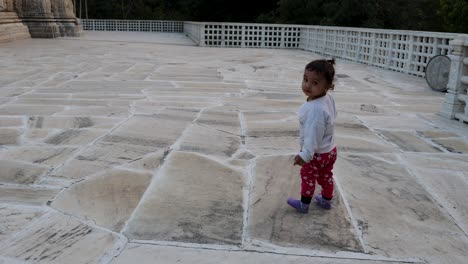 cute toddler walking at temple courtyard at day from unique perspective