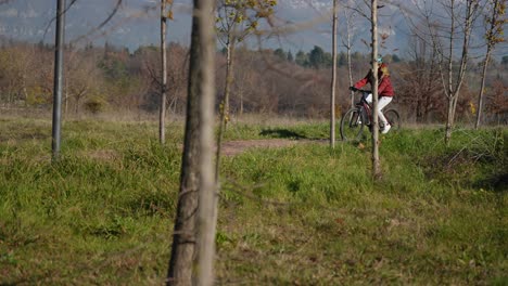 girl biking on park trail with mountain bicycle helmet, winter sunny day, outdoor sport happiness slow motion
