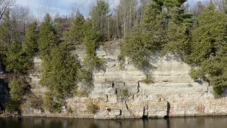 Girl-Rock-Climber-Rappelling-and-Rock-Climbing-a-Steep-Cliff-Wall-of-a-Lake