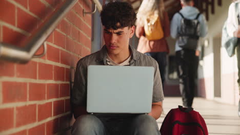 teenage student working on laptop at school