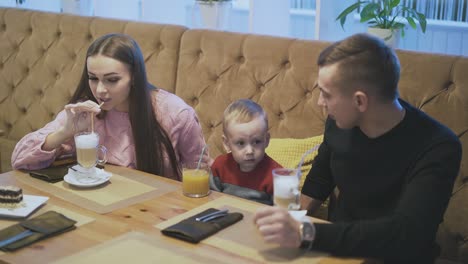 Familia-Feliz-Saborea-Bebidas-En-Un-Restaurante-Con-Maceta