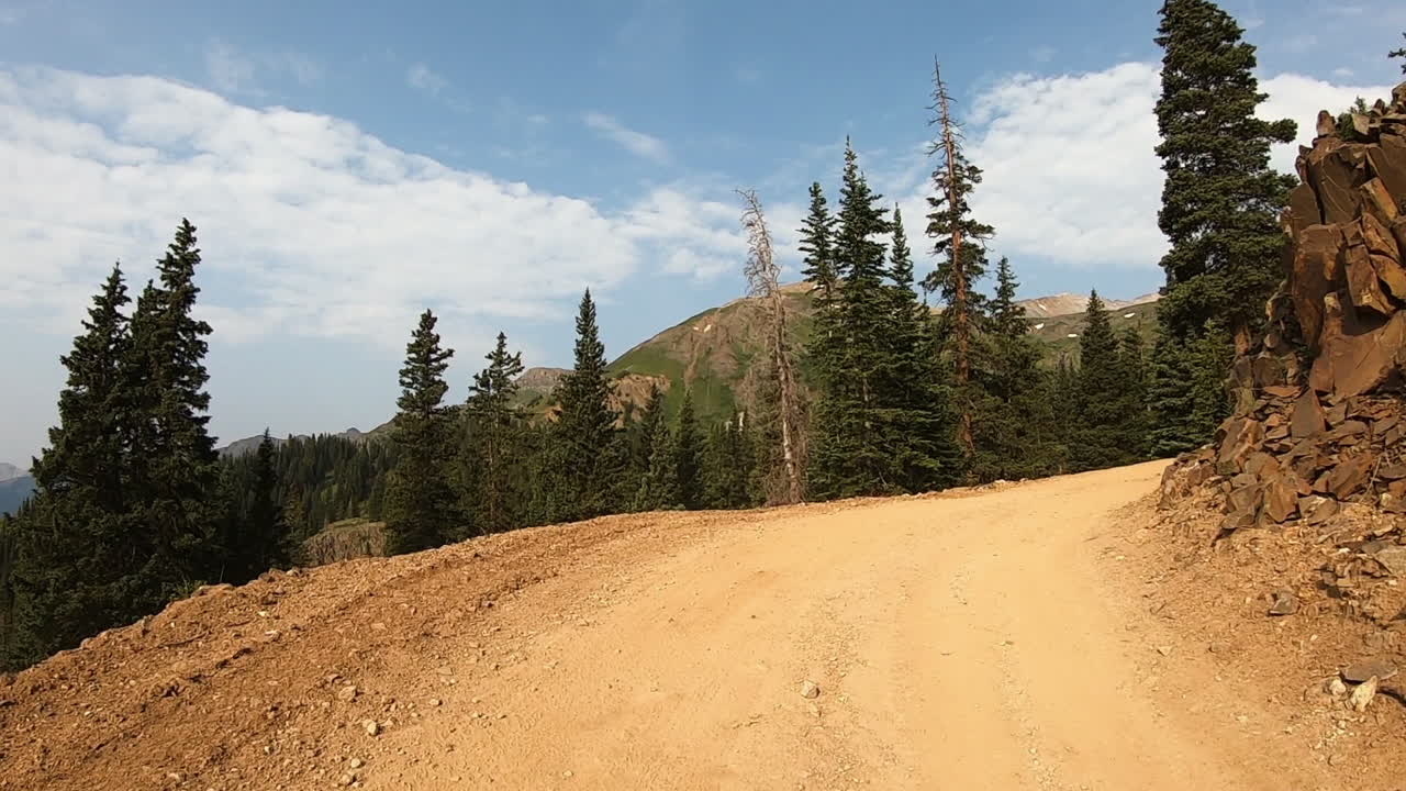 pov mientras conduce un vehículo 4x4 a lo largo de un sendero cortado en la ladera de la montaña sobre la quebrada poughkeepsie cerca de ouray colorado