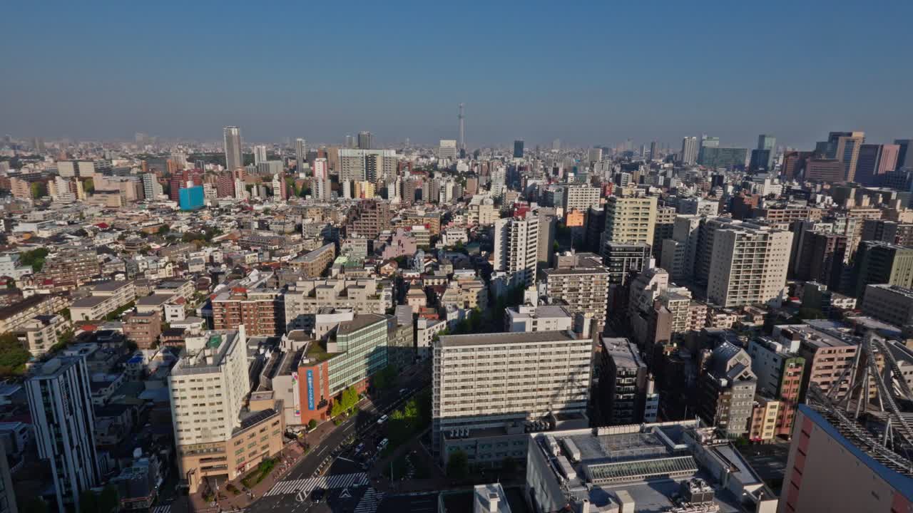 An extensive aerial view of Tokyo's vibrant urban sprawl, including distant landmarks like the Skytree, captured from the Bunkyo Civic Center Observatory on a clear day.