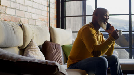 senior man talking on mobile phone in living room 4k