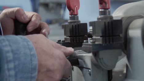 close-up of hispanic man working operating special machine for duplicating lock keys