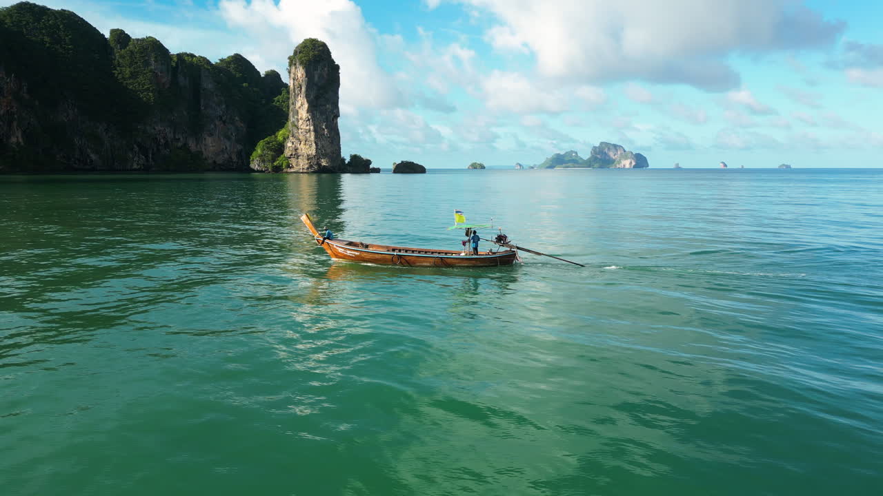 Barca a coda lunga che costeggia la costa di Ao Nang, Krabi, Thailandia.