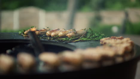 Unknown-man-turning-around-meat-snacks-on-backyard.-Man-using-forceps-outside