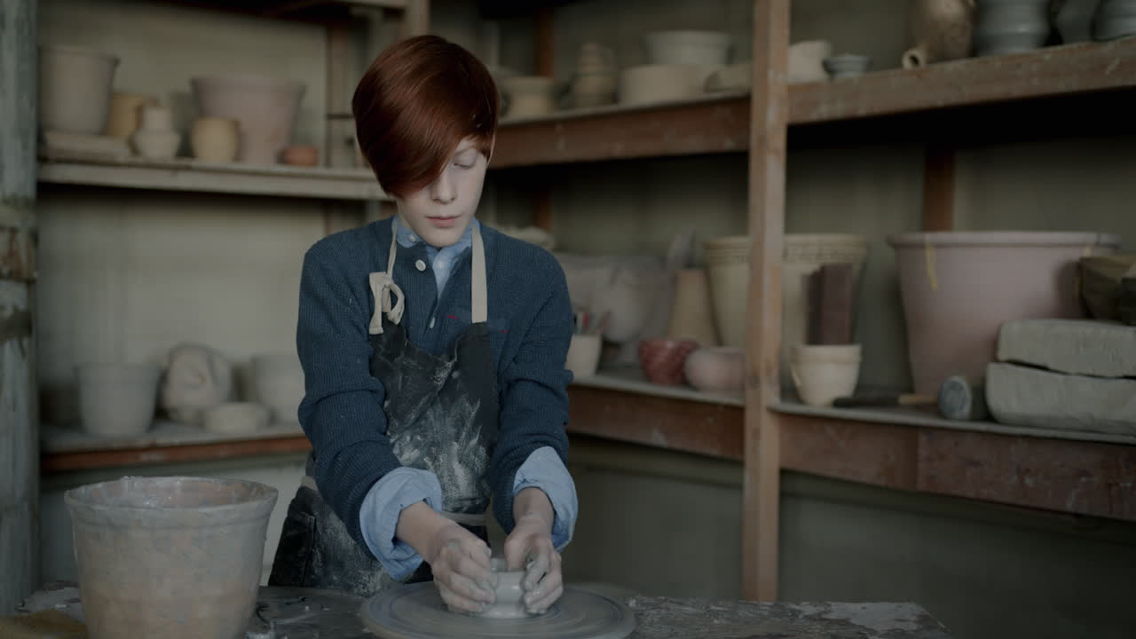 Teenager working on pottery wheel