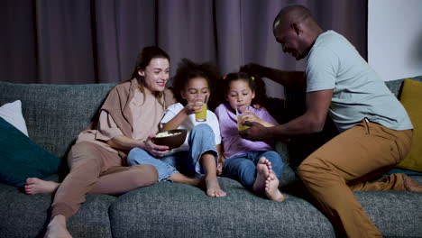 kids with parents watching film at home