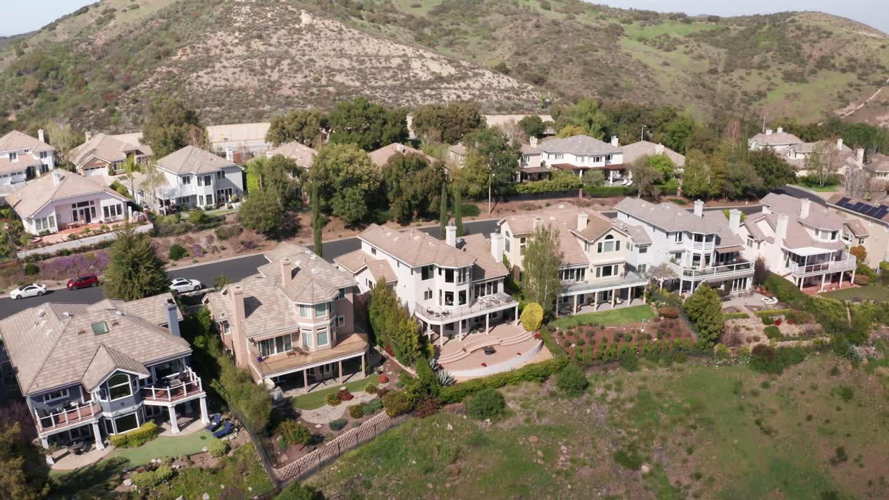 Aerial reverse pullback tilting up shot of upscale homes in the exclusive Lake Sherwood, California. 4K at 30 FPS