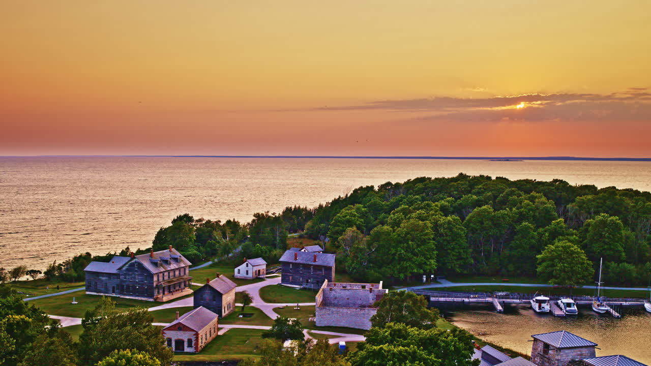 Drone footage flying over old mining ghost town towards lake Michigan at sunset