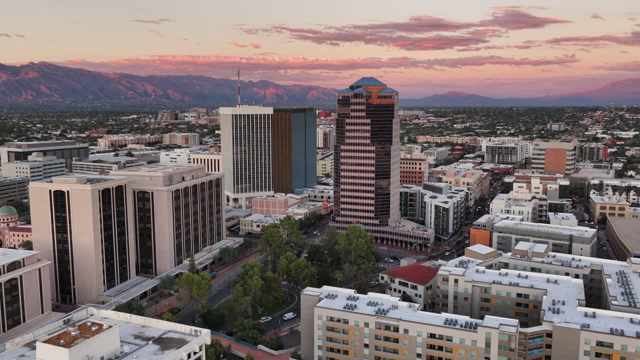 Ascending drone shot of downtown Tucson, Arizona at sunset with Catalina Mountains in background