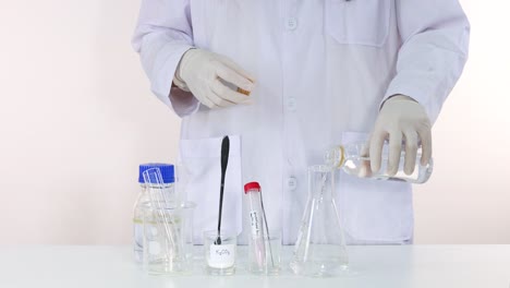 científico vertiendo productos químicos en un experimento de laboratorio