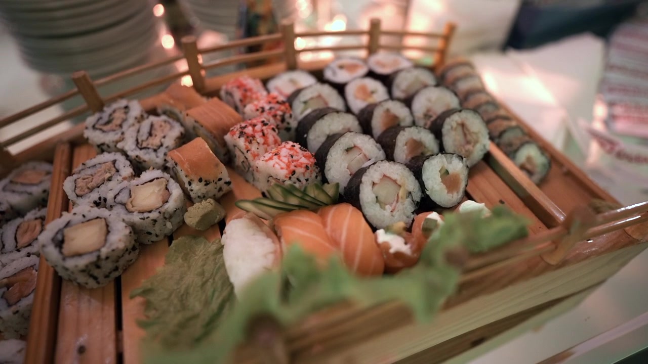 Una varietà di roll di sushi e sashimi elegantemente disposti su un vassoio di legno. Perfetto per presentazioni culinarie o immagini di ristoranti di lusso