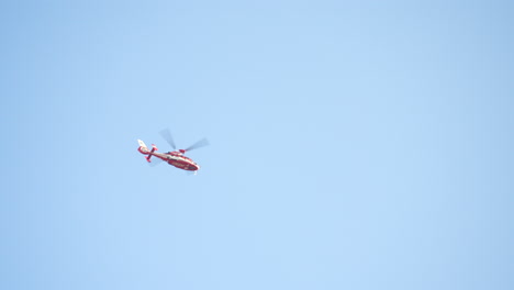 rescue helicopter hovering overhead with blue sky in background in tokyo, japan