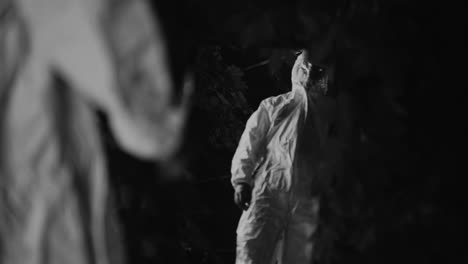 people in protective suits at night