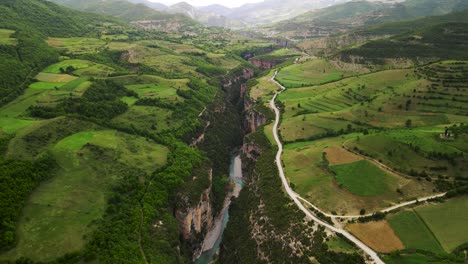 aerial cinematic eagle eye-shot of the osum canyon in albania with a river flowing through the dense green foliage