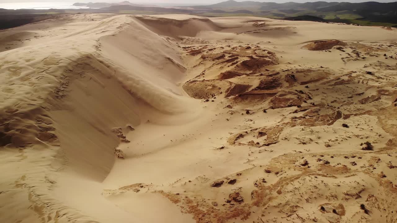 pequeño desierto de arena dorada, vista aérea hacia la empinada pendiente de la duna de arena