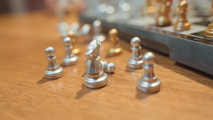 Close-up of Silver Chess Pieces on a Wooden Table