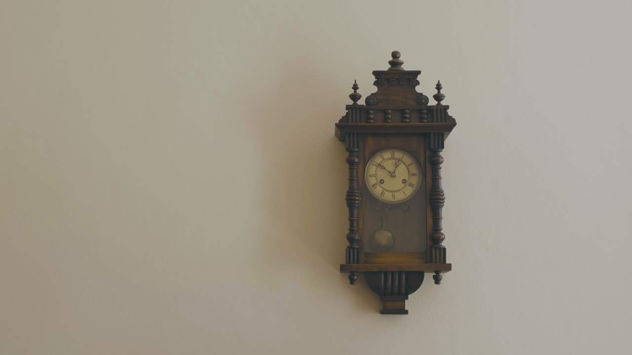 pared rosa claro del interior de una casa con un viejo reloj colgado