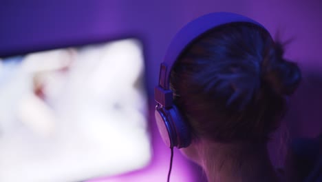 a shot of a female pro gamer from back left-side playing an online video game-2