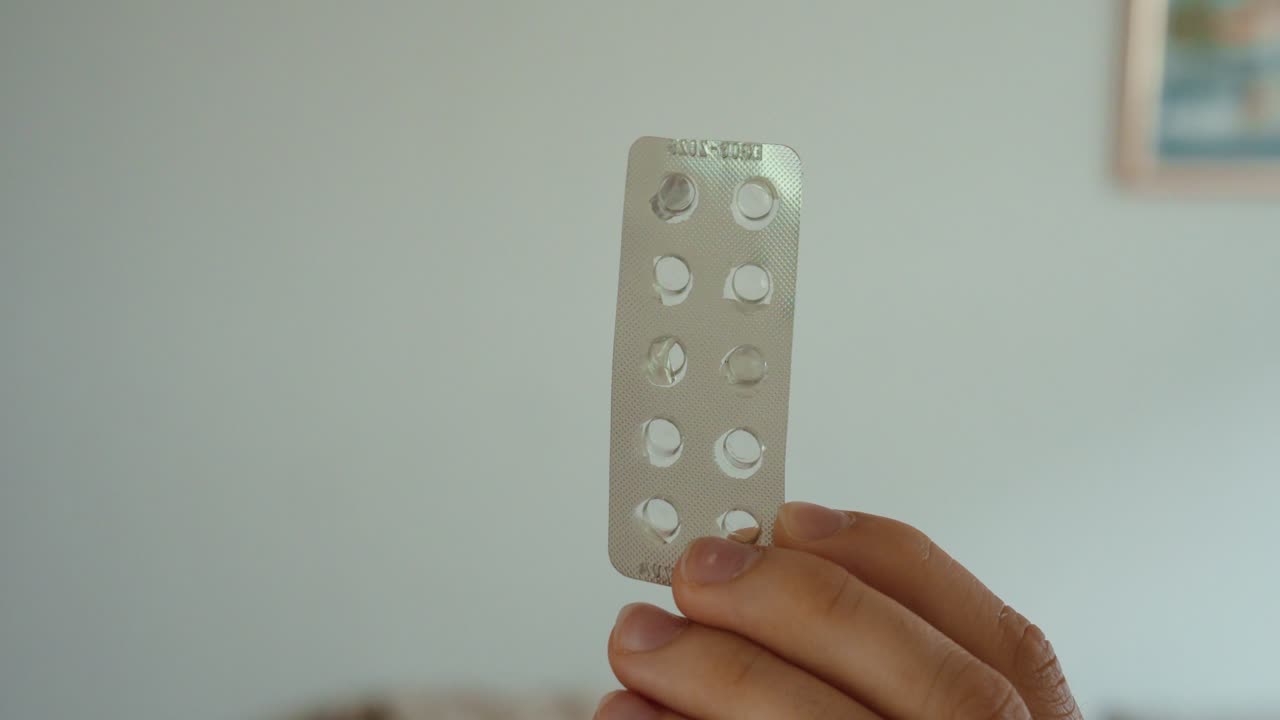 Hånd holder en tom blisterpakke, der symboliserer afsluttet medicinering, gennemført behandling eller mangel på piller.