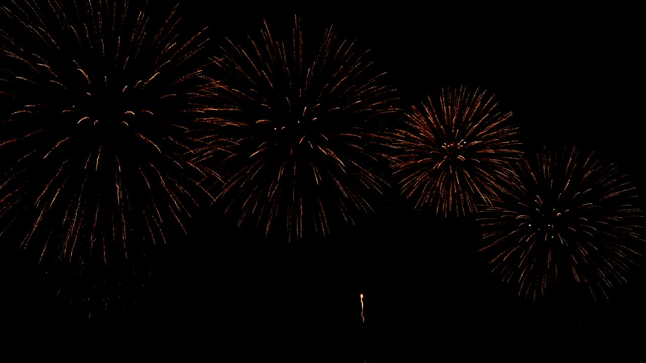 4K. seamless loop of real golden fireworks festival in the sky display at night during national holiday, new year party or celebration event