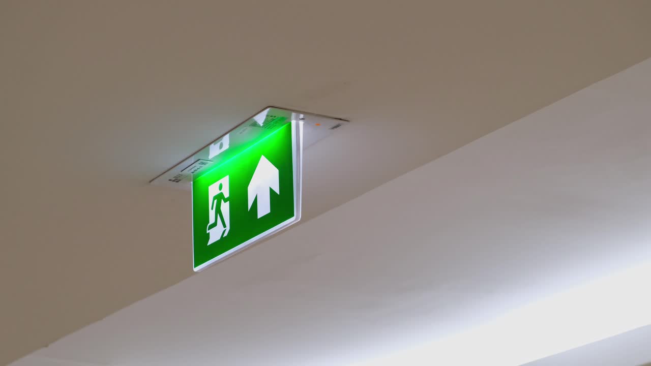 Fire Exit Sign seen fixe on a ceiling of a building in Bangkok, Satey Measure