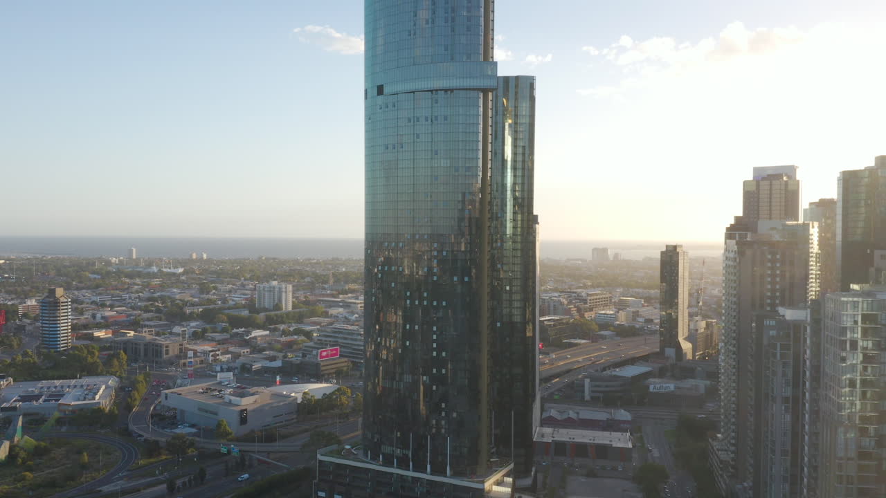статическая воздушная перспектива с видом на современное городское здание в саутбэнке, мельбурн, австралия, с движущимся транспортом, проносящимся мимо по соединительным магистралям внизу