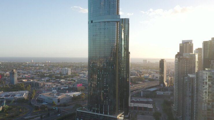 Perspectiva aérea estática de um edifício urbano moderno em Southbank, Melbourne, Austrália, com tráfego fluindo rapidamente nas autoestradas de ligação abaixo.