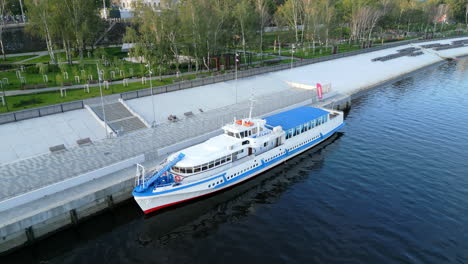 passenger boat docked at a modern riverside park embankment