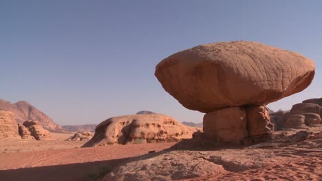 a rock shaped like a mushroom stands in the saudi desert near wadi rum jordan