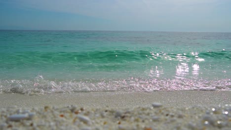 slow motion of marble beach with vivid crystal clear water, clear blue sky in the background, white sandy beach, thassos island, greece