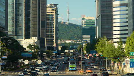 korean people commute through busy seoul downtown, cars traffic in city center with namsan tower view near sinyongsan station