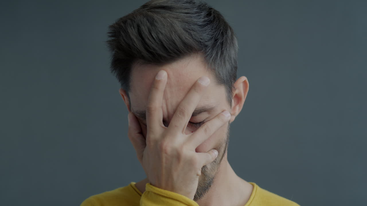 hombre escondiendo la cara