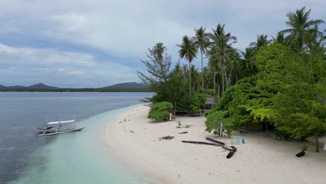 Static-aerial-shot-of-banca-outrigger-canoe-on-sandy-balabac-beach-shoreline