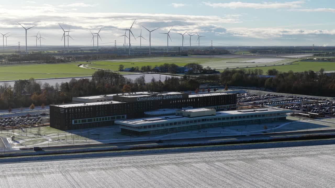 Aerial drone video footage of the modern Ommelander Hospital in Scheemda, Groningen, in a winter landscape. The facility is a sustainable, energy-efficient, and welcoming healthcare building