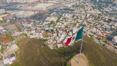 mexican flag in a windy day in a north mexican city