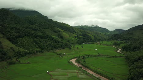 aerial view flying above lush green tropical rain forest mountain with rain cloud cover during the rainy season on the doi phuka mountain reserved national park the northern thailand