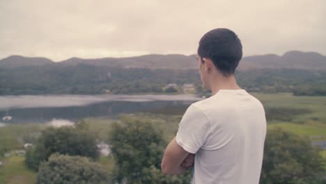 a young man overlooking a scenic lake view