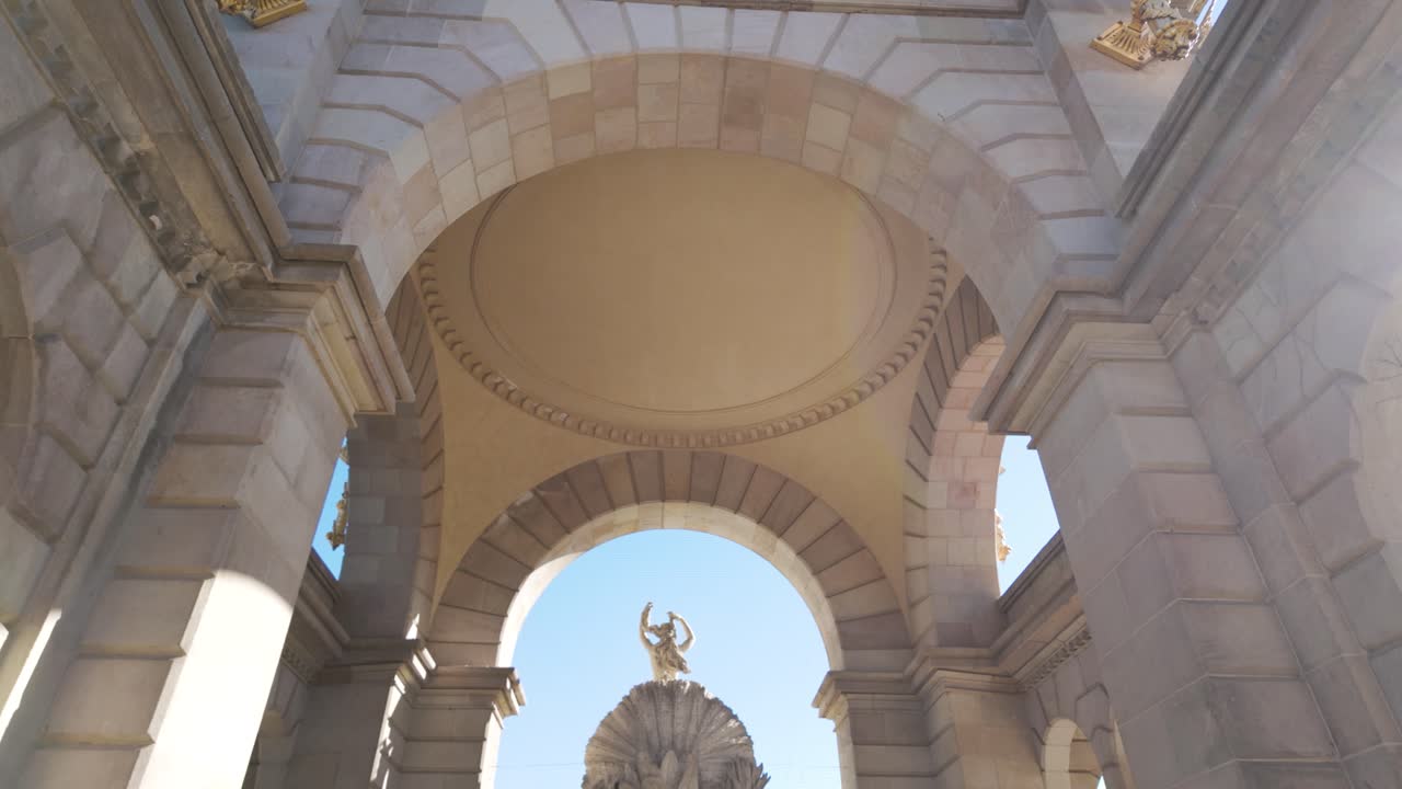 vista de una escultura clásica detallada en la cascada monumental, enmarcada por un arco bellamente diseñado en barcelona. la elegancia arquitectónica mejora la atmósfera histórica y cultural.