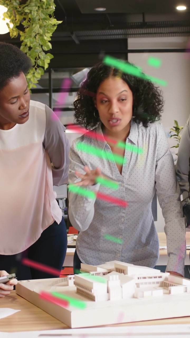 Vertical video: Lead presenter reaching toward design model, leading review amid red green streaks