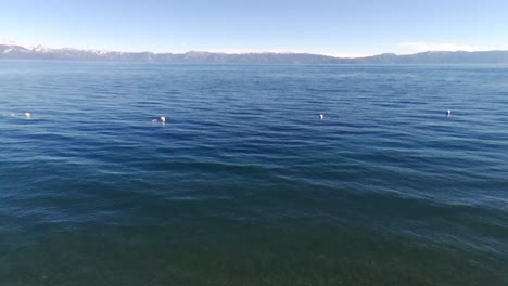 Aerial-shot-of-lake-with-blue-water-and-waves-in-Lake-Tahoe,-NV,-USA